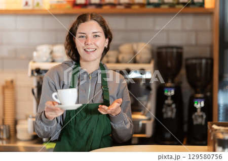 Girl coffee shop employee is waiting for customers Girl coffee shop employee is waiting for customers 129580756