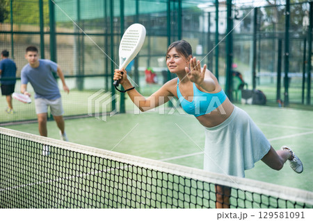 Attractive woman padel tennis player training on court Attractive woman padel tennis player training on court 129581091