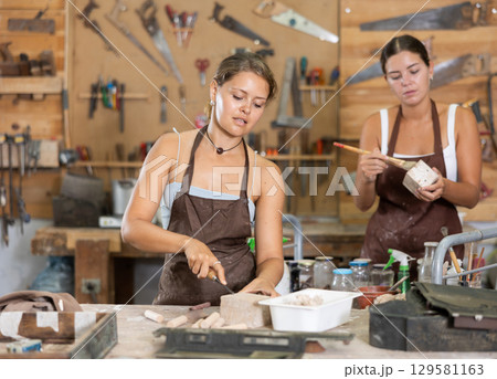 Girl working with wood in carpentry workshop 129581163