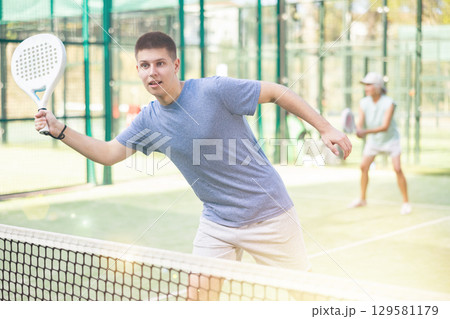 Man training to play tennis on padel court outdoor Man training to play tennis on padel court outdoor 129581179