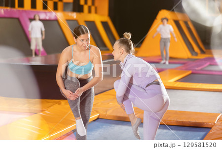 Young woman and adult woman in training for trampolining Young woman and adult woman in training for trampolining 129581520