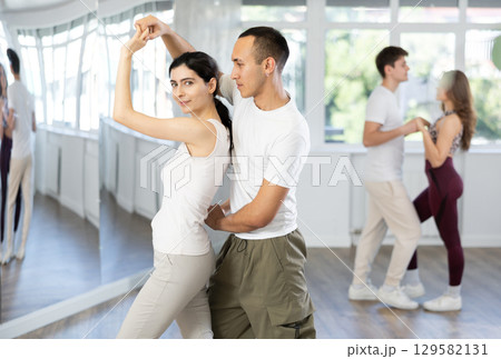 Young couple dancing playful bachata in choreography studio 129582131