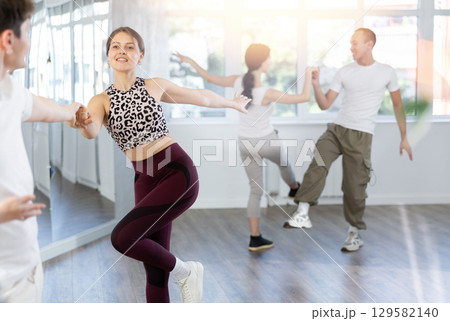 Girl paired up with young man, they train to perform disco fox dance, rehearse performance. 129582140