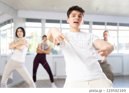 Guy enjoys active dancing, learns new movements, moves synchronously with participants of lesson Guy enjoys active dancing, learns new movements, moves synchronously with participants of lesson 129582169