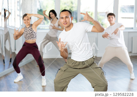 Team of dancers performing contemporary dance in choreography studio Team of dancers performing contemporary dance in choreography studio 129582228