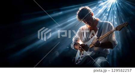 Guitarist performing on stage with dramatic lighting effects Guitarist performing on stage with dramatic lighting effects 129582257