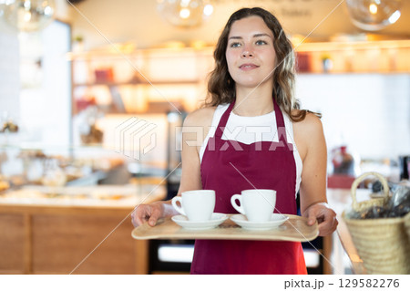 Seller carries a tray with cups of coffee Seller carries a tray with cups of coffee 129582276