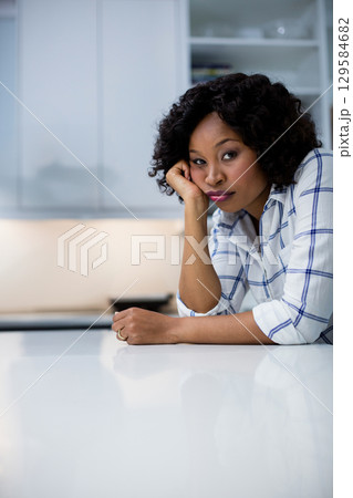 African American woman leaning on kitchen counter gazing while showing ring on hand, copy space African American woman leaning on kitchen counter gazing while showing ring on hand, copy space 129584682