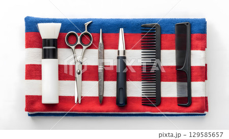 Essential barber tools arranged on a striped towel in a grooming setup for professional use 129585657