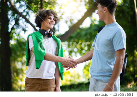 Friends meeting in the park after school and looking excited 129585681