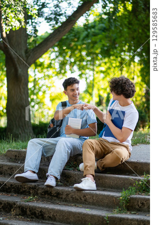 Two friends spending time together in the park after school 129585683