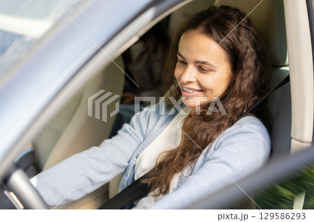 Young woman and her daughter sitting in the car and looking joyful 129586293