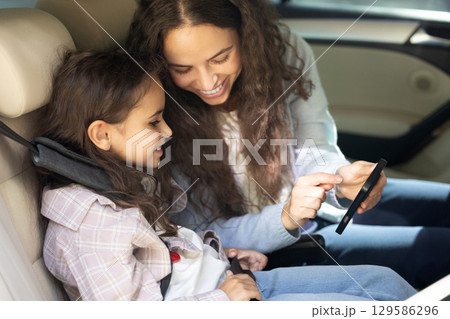 Mom and daughter in a car feeling happy and pleased 129586296