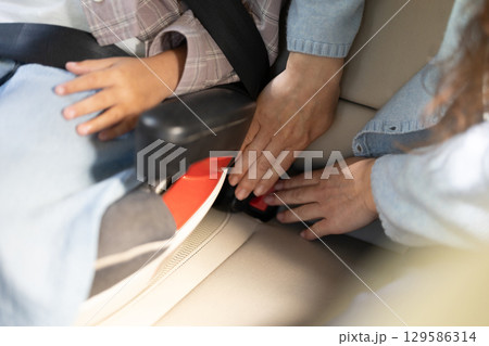Close up picture of hands assembling safety belts in the car 129586314