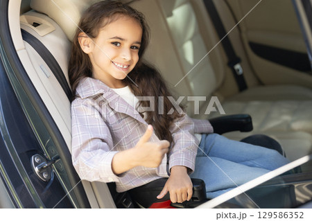 Sweet girl of school age in the car drawing and looking peaceful Sweet girl of school age in the car drawing and looking peaceful 129586352