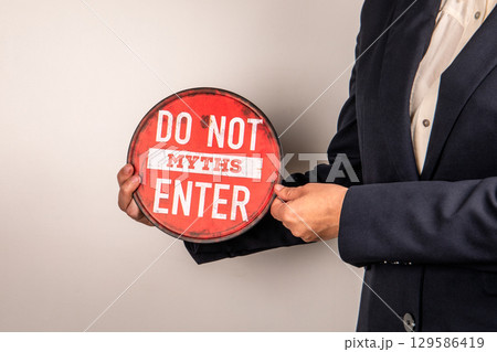 Businessman Holding Do Not Enter Myths Warning Sign Against False Information 129586419