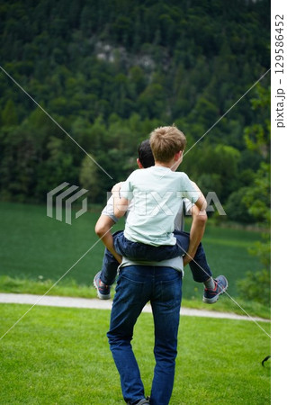 Child Piggyback Ride in Scenic Green Landscape 129586452