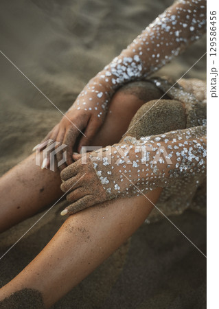 Hands with Glitter on Sandy Beach Closeup Hands with Glitter on Sandy Beach Closeup 129586456