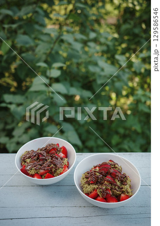 Homemade Dubai chocolate strawberry cup desserts with kataifi, pistachio paste, milk chocolate and fresh strawberries. vertical photo. Street food desserts and sweets. Copy space for text. Homemade Dubai chocolate strawberry cup desserts with kataifi, pistachio paste, milk chocolate and fresh strawberries. vertical photo. Street food desserts and sweets. Copy space for text. 129586546