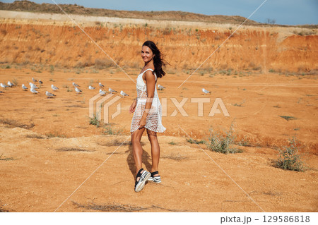 brunette in white summer dress in the desert brunette in white summer dress in the desert 129586818