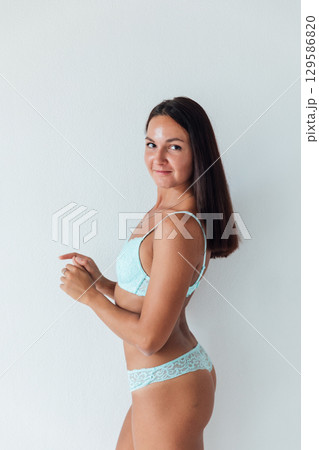 brunette in light lingerie on white background 129586820