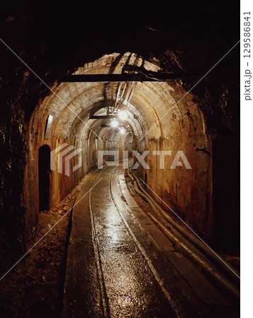 レールのあるカーブした坑道 129586841