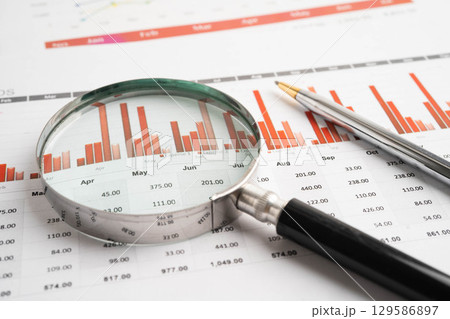 Magnifying glass on charts graphs paper. Financial development, Banking Account, Statistic, Investment Analytic research data economy. 129586897