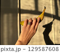 Oval diamond engagement ring with banana against shadowed wall 129587608