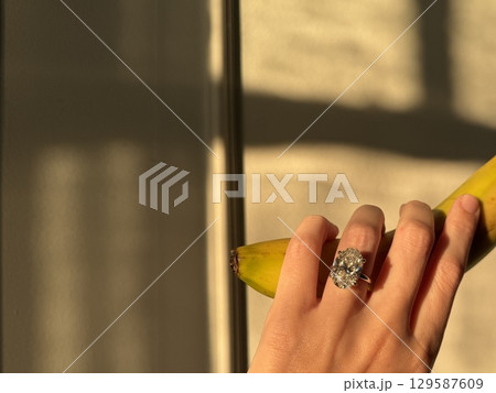 Diamond engagement ring and banana in golden afternoon light 129587609