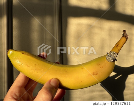 Sparkling diamond ring with banana in warm golden tones 129587611