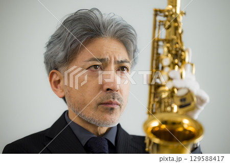 サックスをメンテナンスするシニア男性 129588417