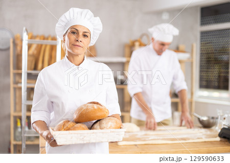 Elderly woman with homemade bread in bakery Elderly woman with homemade bread in bakery 129590633