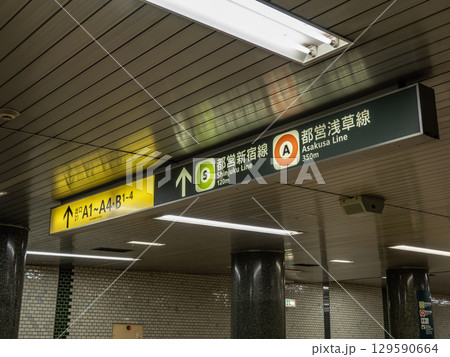 鉄道地下駅の連絡通路に掲示された出口案内と乗り換え案内 129590664