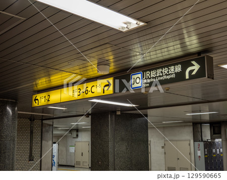 鉄道地下駅の連絡通路に掲示された出口案内と乗り換え案内 129590665