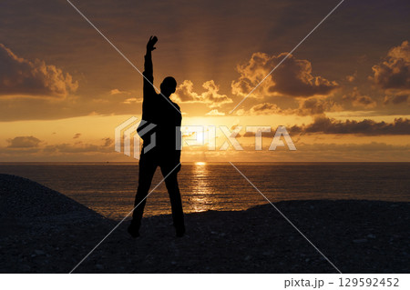 Victorious Silhouette at Sunset. Motivation and Achievement 129592452