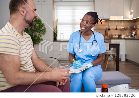 Caring nurse engages in patient consultation at home Caring nurse engages in patient consultation at home 129592520