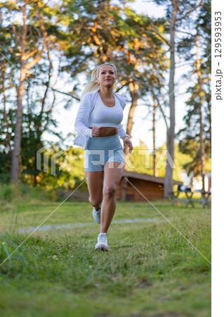 Woman Jogging in a Park During a Sunny Day 129593953