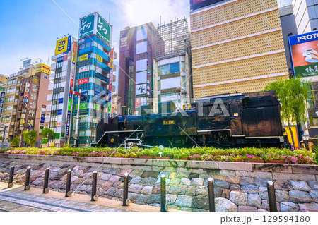 日本の東京都市景観8月8日。夏空が広がる新橋・新橋SL広場前のSLや飲み屋街などを望む 129594180