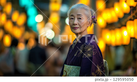 女性が伝統的な着物で夜祭りを歩む 129595050