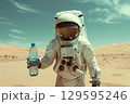 Surreal image of an astronaut holding a bottle of water at a desert. concept of global warming and 129595246