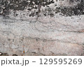 Natural stone wall with wavy Cross-Bedding texture and black stains spot 129595269