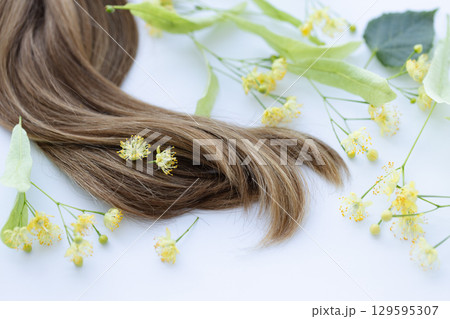 Female hair with yellow linden flowers. Closeup Female hair with yellow linden flowers. Closeup 129595307