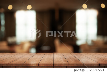 Empty wooden table top with lights bokeh on blur restaurant background. Empty wooden table top with lights bokeh on blur restaurant background. 129597221