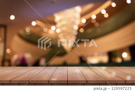Empty wooden table top with lights bokeh on blur restaurant background. Empty wooden table top with lights bokeh on blur restaurant background. 129597225