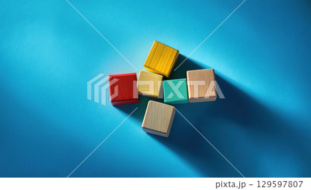 Colorful wooden blocks arranged on vibrant blue background, symbolizing creativity and teamwork 129597807