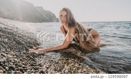 Woman in a Bikini on a Pebbly Beach Woman in a Bikini on a Pebbly Beach 129598097