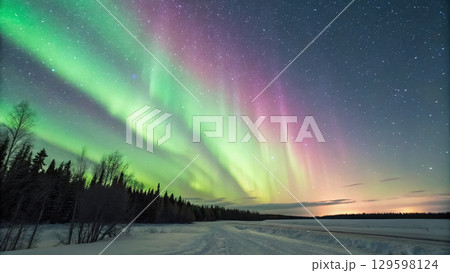 vibrant aurora borealis dancing across night sky, illuminating landscape with green and purple hues 129598124