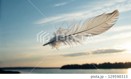 delicate feather floating gently in sky, symbolizing peace and freedom delicate feather floating gently in sky, symbolizing peace and freedom 129598313
