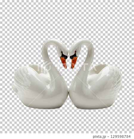 Two white porcelain swan figurines forming a heart shape as a symbol of love and romance 129598784