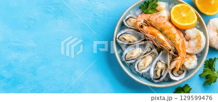 Fresh seafood platter with shrimps, oysters, and lemon slices on ice. Horizontal banner with copy space for text, poster, free space Fresh seafood platter with shrimps, oysters, and lemon slices on ice. Horizontal banner with copy space for text, poster, free space 129599476